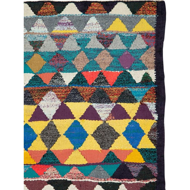 This Mid-20th century Persian flatweave kilim presents a bold, graphic composition built from horizontal bands of...