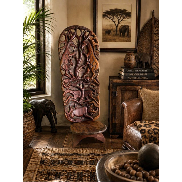 An extraordinary hand-carved chair crafted by artisans in Malawi, showcasing a richly detailed panorama of African...