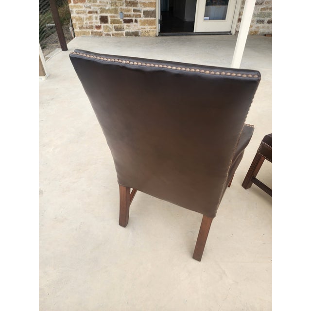 Great looking pair of leather armchairs with brass tack detail and mahogany wood. These are two of six that are available...