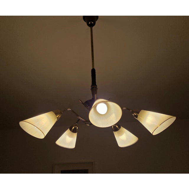 A stylish 5-armed chandelier that evokes the modern design of the 1950s and 1960s. The sputnik ceiling lamp features a...