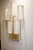 Pair of wall sconces in patinated gold metal, with sycamore bases. The lampshades are white fabric with gold trim. They...