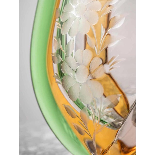 This designer vase is made of brightly colored glass with shades of green, blue, pink, and yellow. This beautiful harmony...