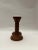 This is a Danish wooden candlestick holder with a copper-colored metal cup at the top. The candlestick has a turned design.