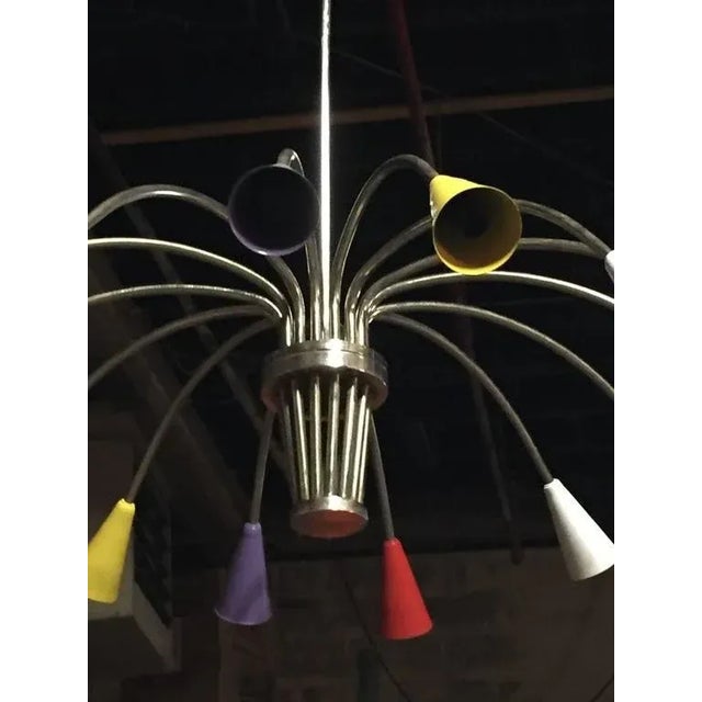 Stunning Italian Mid-Century Modern chrome and multicolor metal cone form shade chandelier. Having central hub supporting...