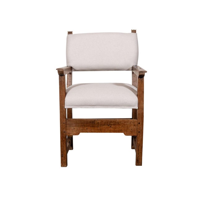 Upholstered accent chair. Square frame with two decorative finials. Straight armrests.