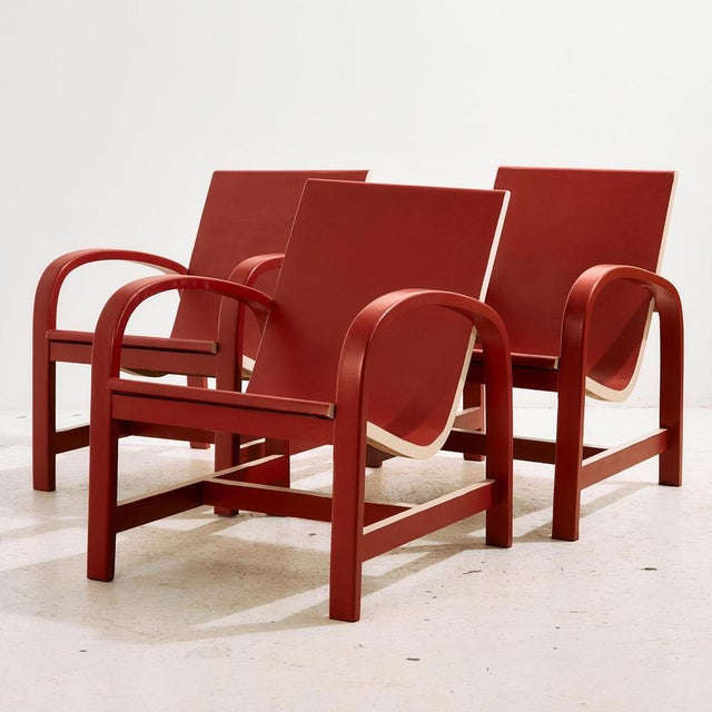 A white and red painted beech armchair with curved shapes from the 1940s. with some surface scratches, stains and wear on...