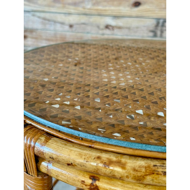 Beautifully restored tortoise rattan drum table featuring a woven cane top protected by brand new round glass. The frame...