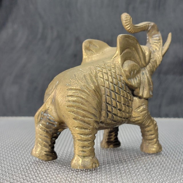 This fabulous 1950s Etched Solid Brass Elephant Figurine Trunk Up will be a one of a kind accent in your home interior,...