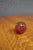 Hand-blown art glass paperweight in the form of an apple with a rich cranberry red body, clear overlay, and applied clear...