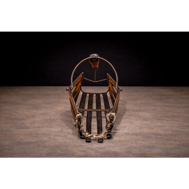 Attributed to a mid-20th century workshop, this sculptural wine holder reflects a utilitarian object resolved with...