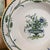 A smartly decorated serving bowl with a delicate garland painted around the rim and an urn and flower composition in the...