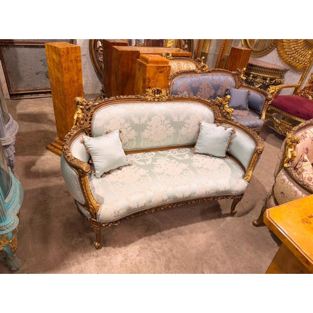 French Louis XV style canapé settee, beautifully crafted with an elaborately carved frame, rich gold finish, and elegant...