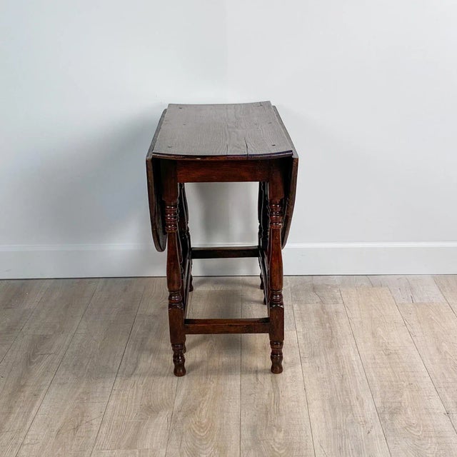An early 18th century English oak drop leaf table. Measures 46.5" w when open.