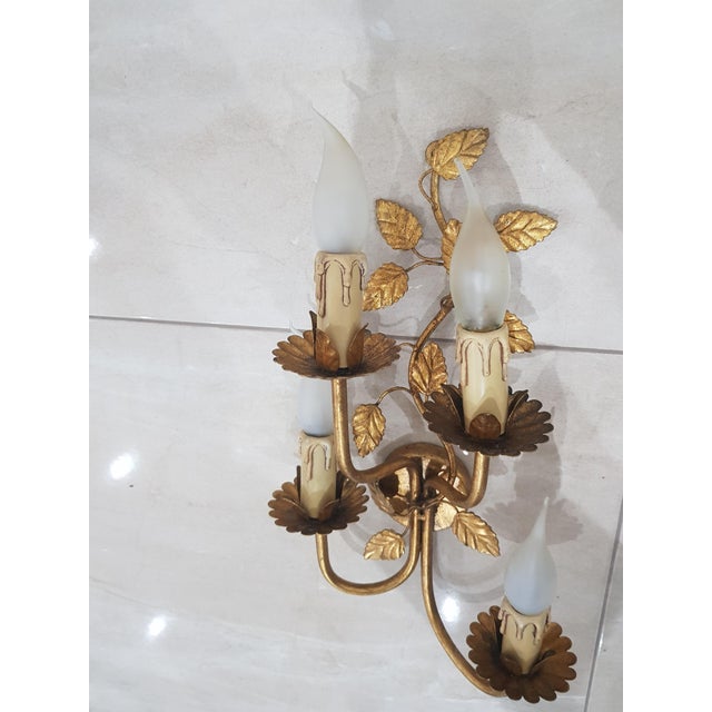 Pair of wall lamps / Coco Chanel / Hollywood Regency / Metal / Gold / France, 1960s. Four-armed wall lamps covered with...