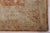 A 10' x 14' hand-knotted wool rug with a rust and terracotta allover floral design on a gold ground, with natural color...