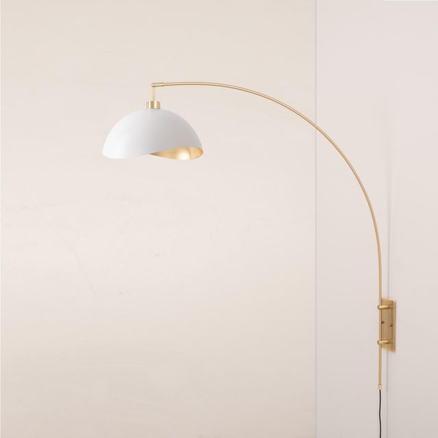 Weathered brass paired with a steel base defines the Luna Bella Wall Arc Lamp, an elegant mid-century modern lighting...