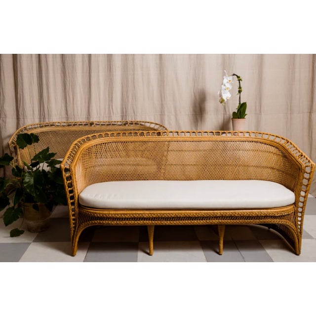 The Amira Moroccan Loveseat features elegant natural wood tones and a distinctive circle weaving detail along the edges....
