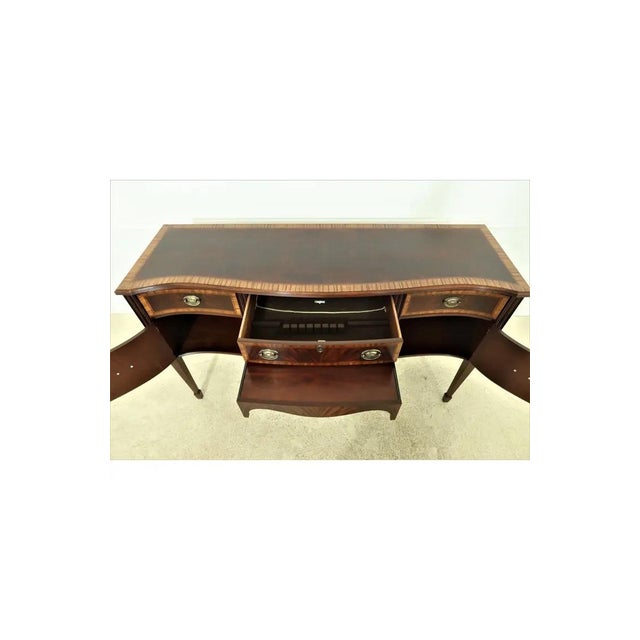 This is a classic flame mahogany Federal-style sideboard with inlay banding around all drawer and door fronts. This piece...