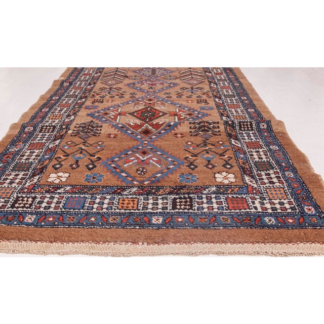 An early 20th century Persian Hamadan runner carpet, the abrashed tan ground with overall geometric and angular floral...