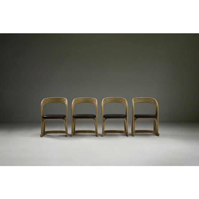 Set of 4 rattan dining chairs, 1980s Italy. Bent, cream-coloured rattan forms the sculptural, organic frame and backrest...