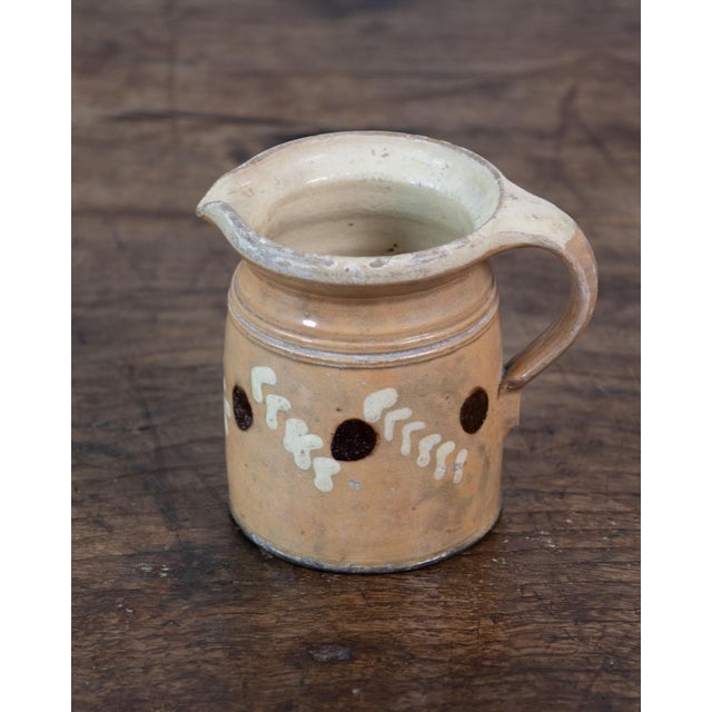 This charming 19th-century French pitcher is crafted from glazed terracotta and reflects the rustic character of...
