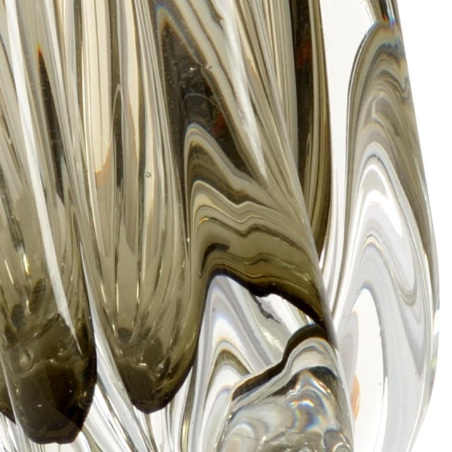 Complete any transitional space with this sleek, modern table lamp. Hand crafted art glass is gently twisted creating a...