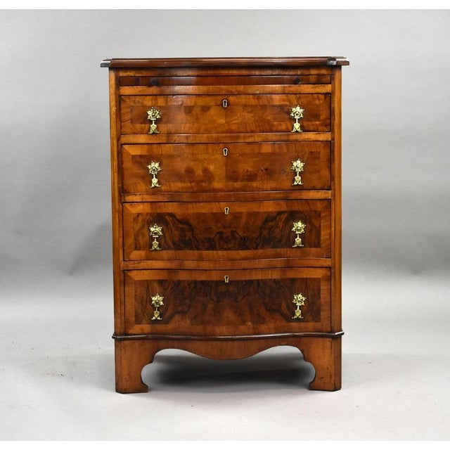 A fine Georgian-style walnut Serpentine bachelor’s chest, of compact proportions, raised on shaped bracket feet. The...