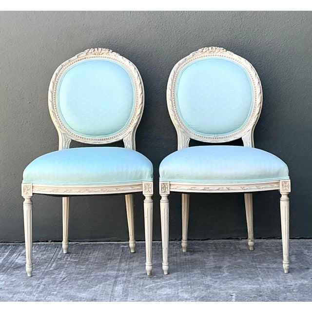 Infuse your home with the classic elegance of this pair of vintage French Regency-style chairs. Featuring the iconic oval...