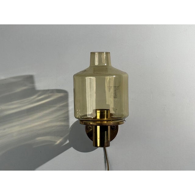 Hans-Agne Jakobsson, Swedish Mid-Century Modern, Wall Light or Wall Sconce, Brass, Glass, Sweden, 1960s A single patinated...