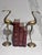 The image features a pair of vintage solid brass crane figurines standing gracefully on round bases with a warm, aged patina.