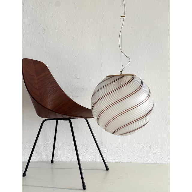 Italian pendant light attributed to Venini manufacturing with large glass sphere with shiny white and brown stripes on...