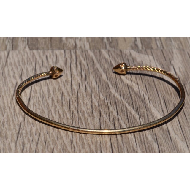 The Belmar Vintage Minimalist Bangle bracelet in Yellow Gold. The bracelet features a larger pointed end which contains a...