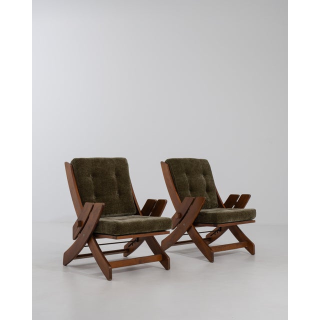 A pair of mid-20th century lounge armchairs featuring adjustable reclining backs, combining functional design with...
