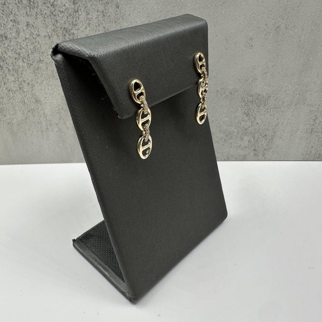 These stylish diamond link earrings in 14kt yellow gold feature 0.15 carats total weight of natural HI SI round diamonds,...