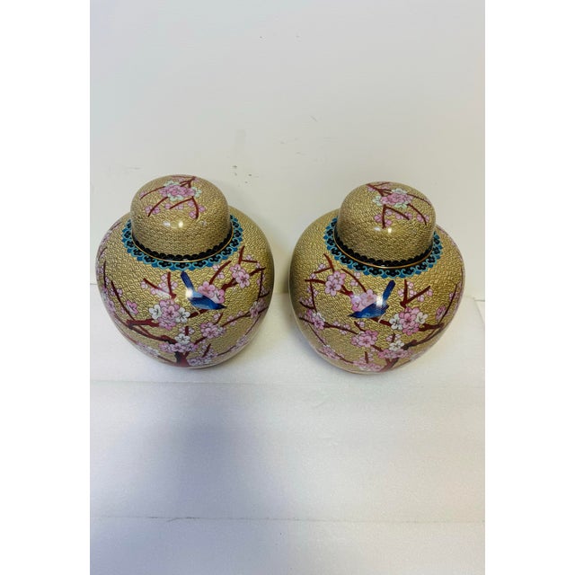 Chinese Pair of Vintage Chinese Cloisonné Ginger Jars Featuring Intricate Enameled Bird and Floral Designs on a Patterned Beige Background. For Sale - Image 3 of 7