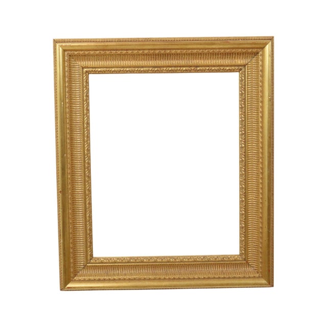 A classic gold-colored wooden frame with a beautiful patina, executed in a Baroque or Rococo style and adorned with...