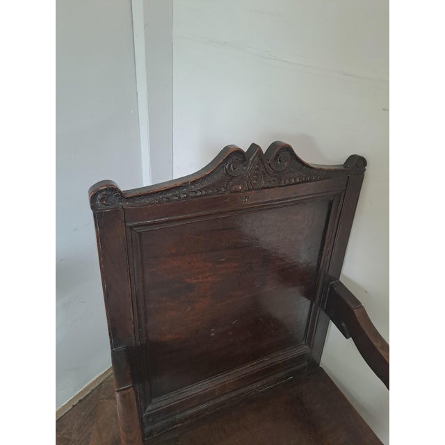 A handsome English oak wainscot armchair, probably late 17th century, with a particularly attractive carved and shaped...
