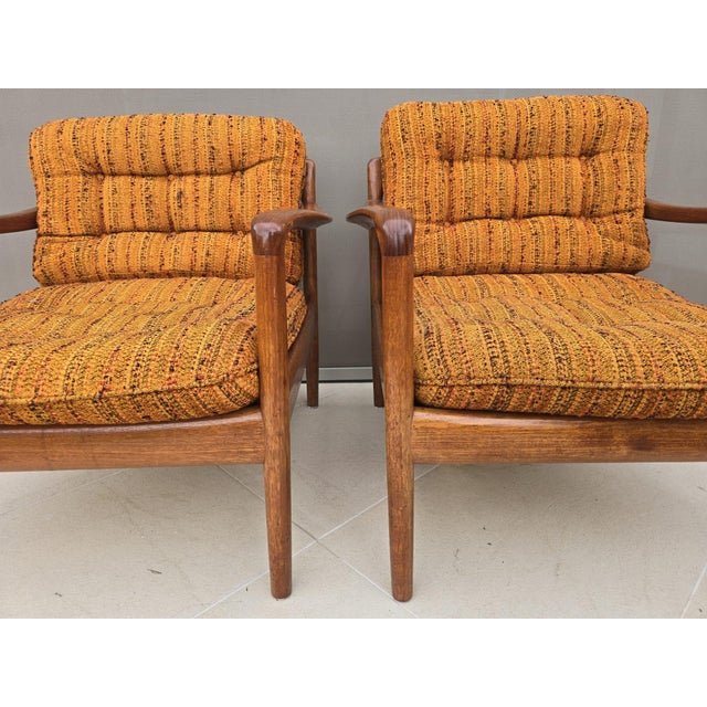 Elegant pair of Scandinavian Modern lounge chairs crafted in solid teak, dating from the 1970s. The chairs feature...