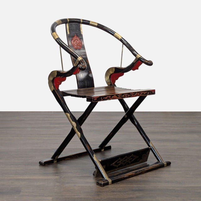 This unique chair features a traditional Chinese horseshoe-shaped back and elegant red and gold detailing. The wooden...