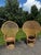 This pair of vintage 1970s boho wicker and rattan peacock chairs features high, dramatic fan backs and hourglass pedestal...