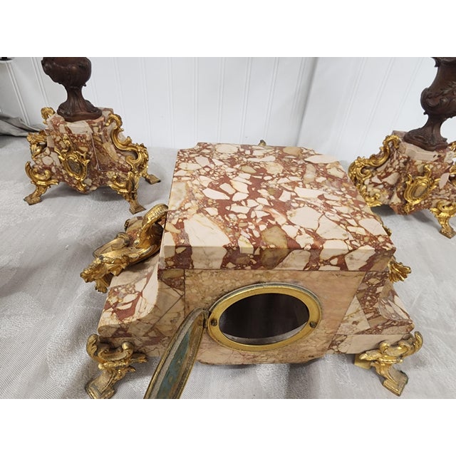 This beautiful trio sits on pink marble bases that will come apart for shipping. The clock no longer has it's inside parts...
