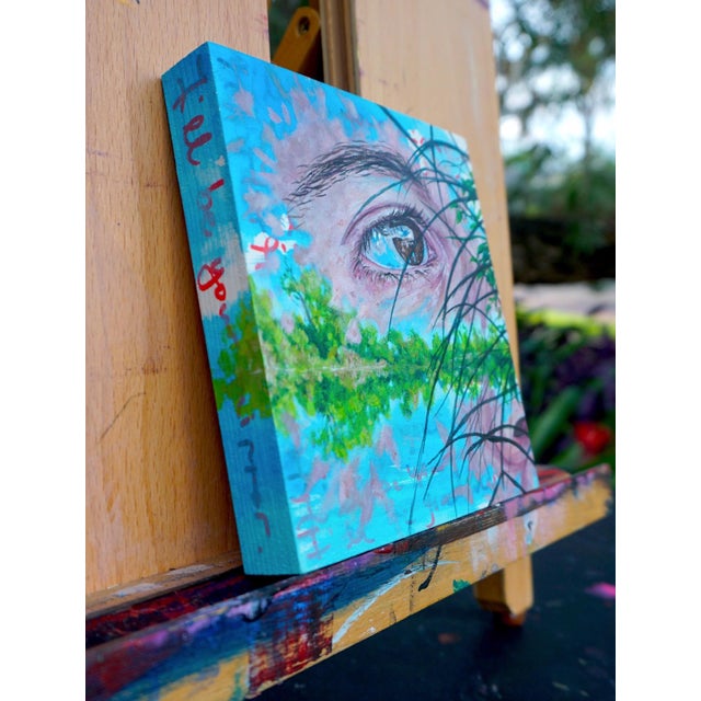 This artwork presents a close-up of an eye reflecting a serene landscape, where vibrant greens and blues meld seamlessly....