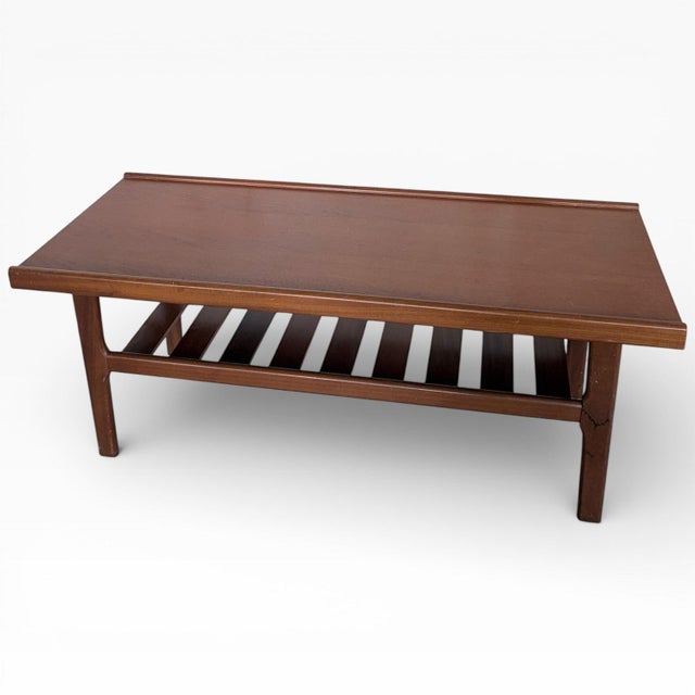 A beautifully proportioned mid century surfboard coffee table crafted in walnut and teak. Featuring a gently curved,...