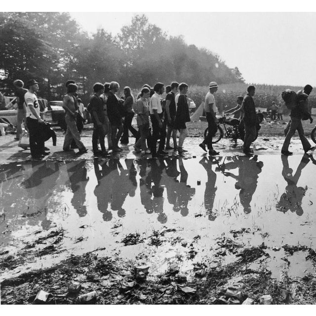 People walking alongside puddle at Woodstock in Bethel NY 1969 Photographer is Fred McDarrah Over a 50-year span, McDarrah...