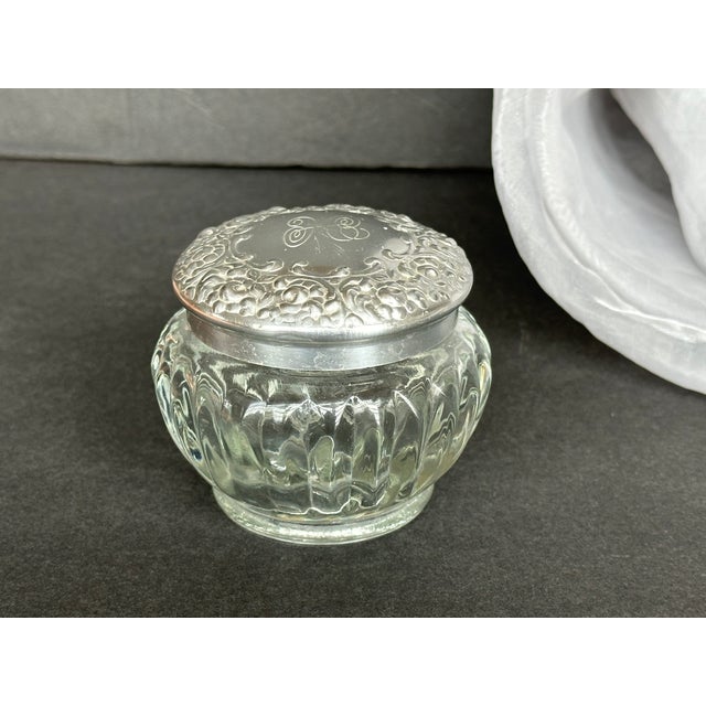 Use this lovely vintage glass jar with its decorative silver repousse lid to hold small items on your bedroom dresser or...