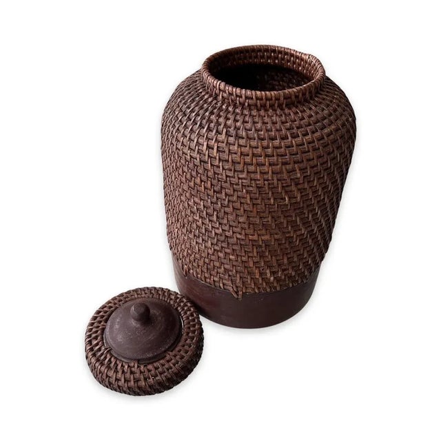 A vintage large Filipino Handwoven Rattan Brown lidded Ginger Jar From Philippines with wood base. This beautiful jar is...