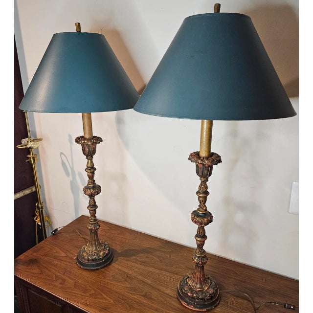 This exquisite Pair of Vintage Italian Baroque Painted and Gilt Carved Wooden Candlestick Style Table Lamps has ornate...