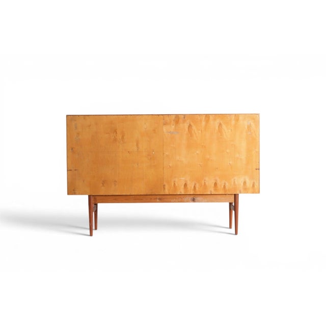 This versatile Danish teak sideboard combines elegant storage with functional details rarely found together in one piece....