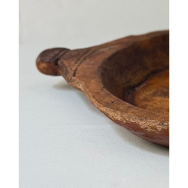 Antique European hand-carved wooden dough bowl or trencher, carved from a single solid piece of wood with integrated...