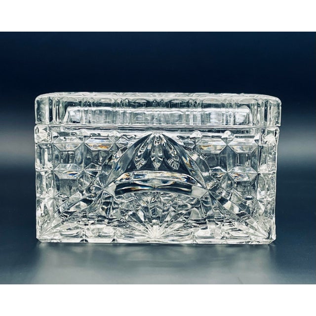 A vintage pressed glass tabletop box with an elaborate pattern which catches the light beautifully.